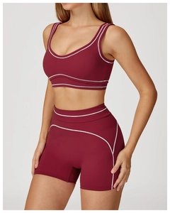 Detail of burgundy yoga set featuring contrast white stitching and U-neck sports bra