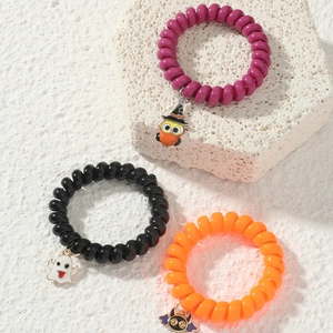 Detailed view of Halloween spiral hair ties with owl, ghost, and bat enamel charms