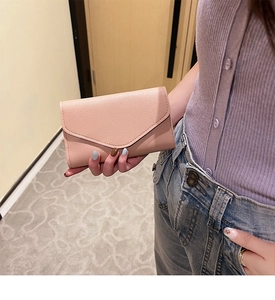 Lifestyle shot of a pale pink envelope passport wallet with premium lychee leather texture