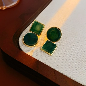 Detailansicht asymmetrischer smaragdgrüner Harzohrringe mit elegantem Goldrahmen