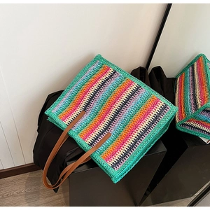 Macro detail of the colorful crochet knit pattern and brown leather handle on this tote