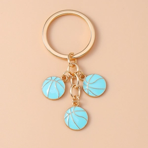 Detailed view of golden metal keychain with three light blue enamel basketball charms