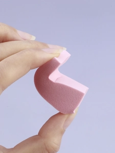 Macro shot of pink non-latex triangle makeup sponge showing soft texture and fine pores