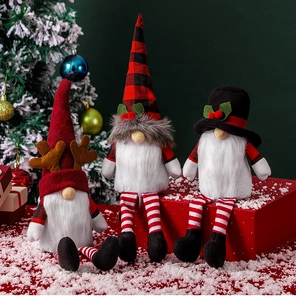 Detailed view of three Christmas gnomes with plaid hats and reindeer antlers on red gift boxes