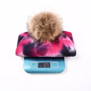 Bonnet en tricot tie-dye avec pompon en fausse fourrure brune pesant 123g sur balance