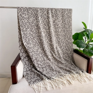 Detail view of leopard print jacquard scarf featuring soft texture and grey fringe