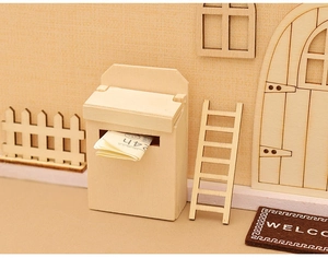 Boîte aux lettres miniature en bois avec journal dans une scène de maison de poupée
