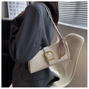 White crocodile pattern underarm bag with gold hardware and decorative silk scarf detail
