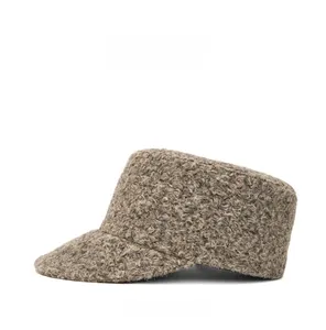 Detail showing the curly wool texture and warm fabric of the grey-brown flat top cap