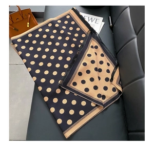 Detailed macro shot of reversible polka dot scarf fabric with elegant tassel trim edge