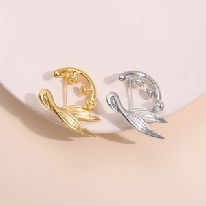 Detailansicht der kreativen Meerjungfrau-Broschen in Gold und Silber auf einem Ständer