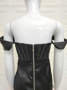 Détail du dos d'une robe noire à paillettes avec une fermeture éclair métallique argentée