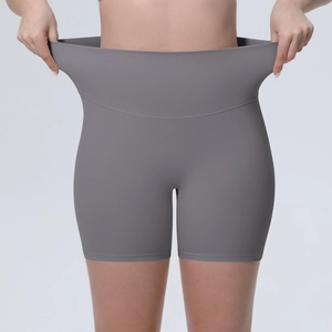 Gros plan sur la haute élasticité et l'extensibilité du short de yoga gris taille haute