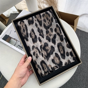 Leopard print voile scarf folded in a minimalist black gift box for elegant gifting