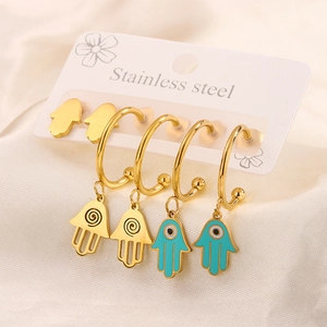 Detail of stainless steel Hamsa and blue Evil Eye charm hoop earrings set on display card