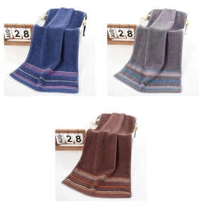 Detail of soft cotton face towels in blue, grey, and coffee with striped hem finish