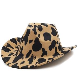 Detail of thickened felt cowboy hat featuring brown and black cow print and rolled brim