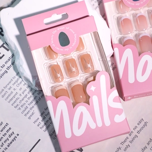 Pink gradient French press-on nails with silver bow charms in elegant paper packaging