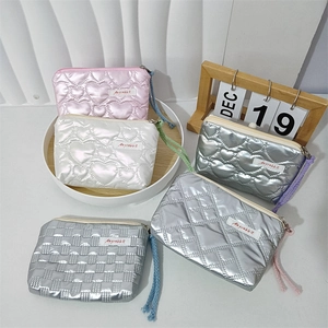 Multiple quilted heart PU pouches in pink, white and silver on a white tray