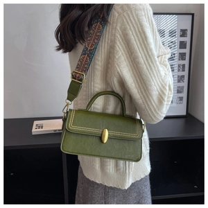 Detail of olive green PU leather handbag with golden studs and patterned strap