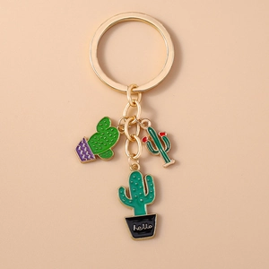 Close-up of golden keychain featuring three green cactus pendants with hello text
