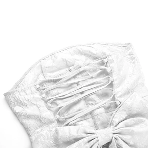 Détail de mini-robe jacquard blanche avec dos lacé et grand nœud décoratif élégant