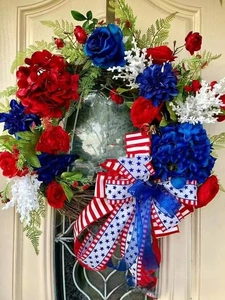 Detail of American patriotic wreath with red blue flowers and a stars and stripes bow