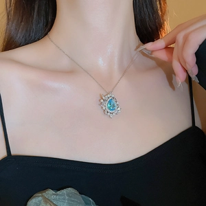 Detail of blue teardrop gemstone necklace with pearls worn on neck for elegant jewelry look