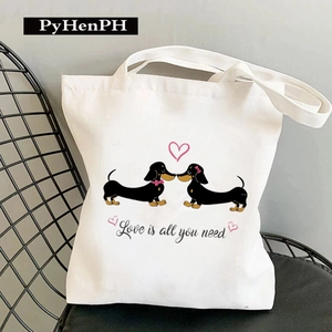 Dachshund print canvas tote bag featuring Love Is All You Need text on black chair