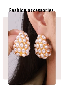 Detailed view of teardrop pearl earrings in 18k gold plating on a model's ear
