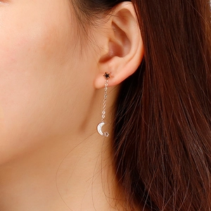 Star and moon drop earrings in silver steel worn by a model for a chic look