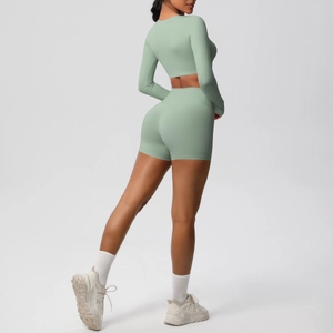 Close-up of sage green brushed yoga set featuring long sleeve crop top and biker shorts