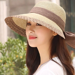 Women's summer straw sun hat with wide brown ribbon bow for beach vacations