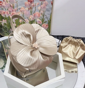 Macro detail of champagne gold floral tote bag with pearl center and matching drawstring pouch