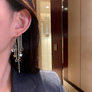 Elegant gold fringe star tassel earrings with rhinestones on female model