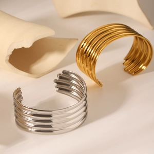 Polished gold and silver multilayer striped open bangles in minimalist artistic setting