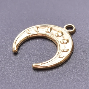 Macro shot of 18k gold plated crescent moon pendant with textured surface and ring loop