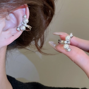 Detail of silver pearl ear cuff with zircon accents for non-pierced ears on a model