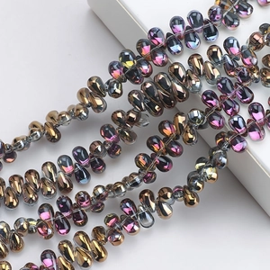 Detailed view of iridescent teardrop glass beads with metallic purple and pink finish