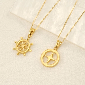 Detailed close-up of gold nautical ship wheel and compass star pendants on fine chains