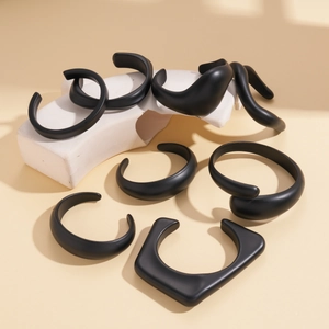 Close-up of matte black geometric acrylic bangles in assorted irregular shapes and sizes