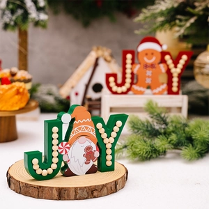 Detail of wooden JOY Christmas tabletop ornaments with gingerbread man and gnome figures