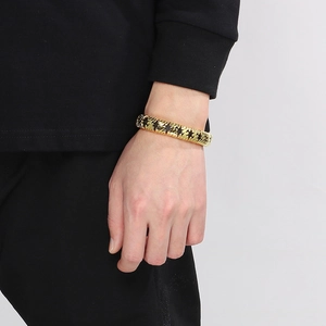 Close-up of a woven gold-plated titanium steel bracelet on a male model's wrist