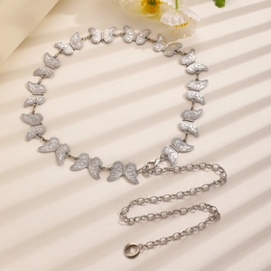 Detail of silver metal waist chain featuring butterfly links and shiny lobster clasp
