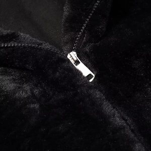 Detailed macro shot of a silver metal zipper on a premium black plush faux fur jacket