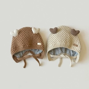 Dettaglio di cappelli di maglia per neonati in marrone e beige con cuori e lacci