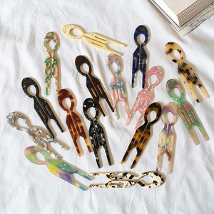 U-shaped acetate hair pins set in leopard, marble and amber patterns on white fabric