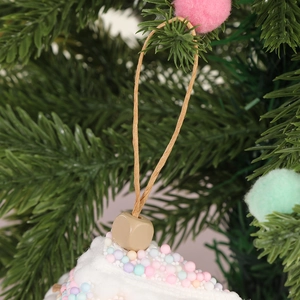 Weißer Weihnachtsschmuck in Tortenform mit bunten Schaumstoffbällen am Weihnachtsbaum