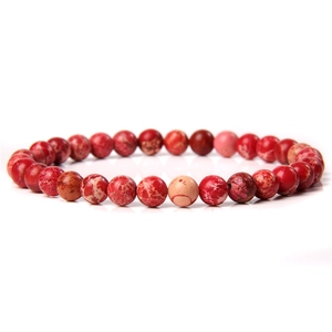 Macro detail of 6mm red natural stone beads showing unique textures on an elastic bracelet
