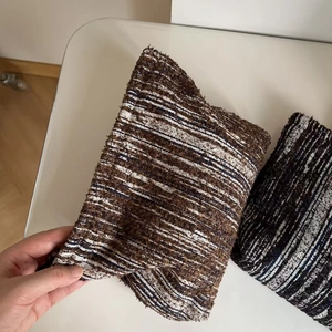 Close-up of woven tweed pouch showing brown and beige textured striped fabric